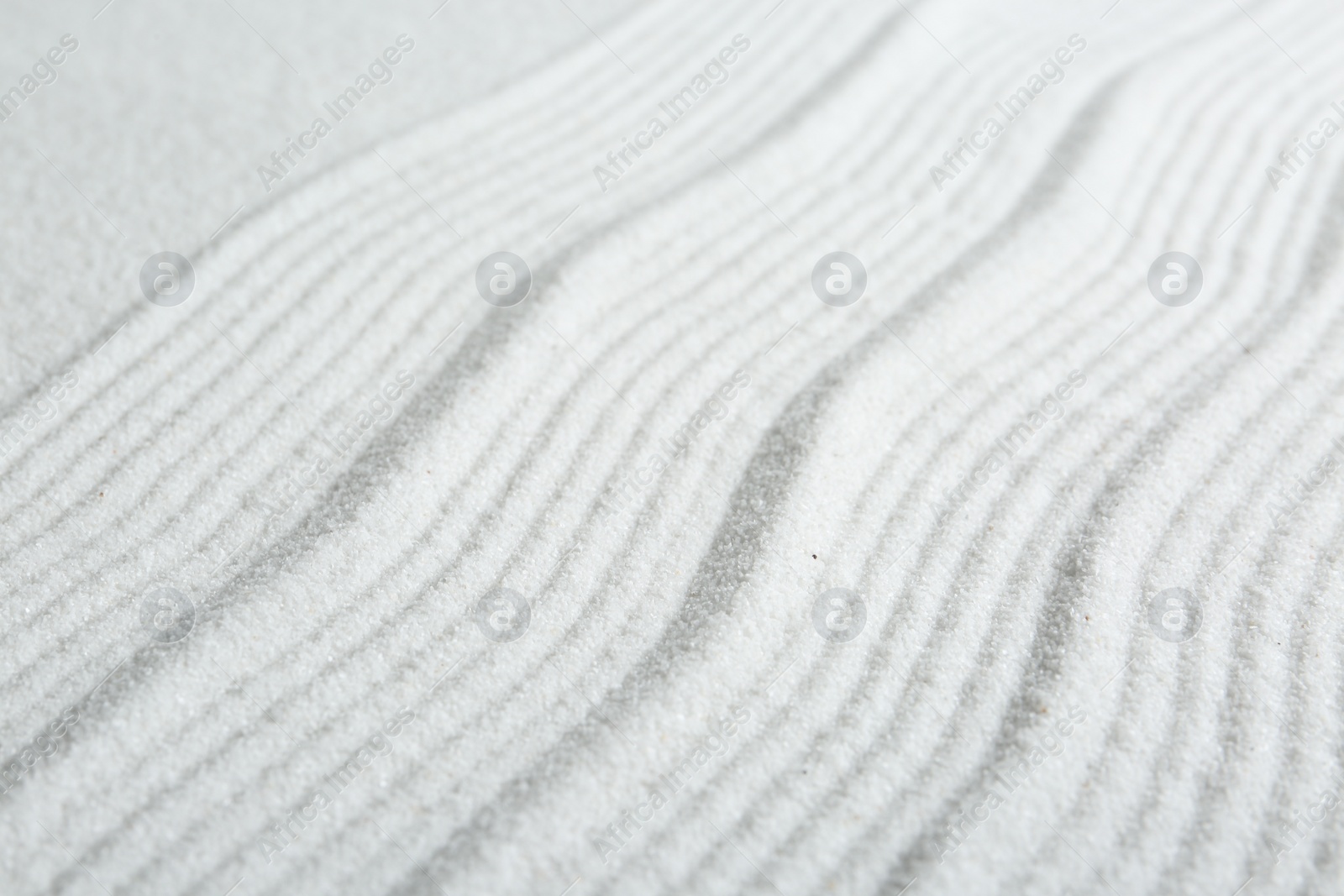 Photo of Zen rock garden. Wave pattern on white sand, closeup