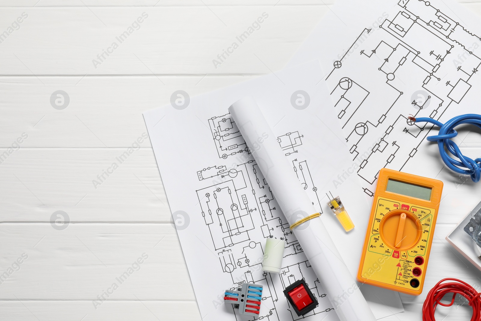 Photo of Flat lay composition with wiring diagrams and digital multimeter on white wooden table, space for text