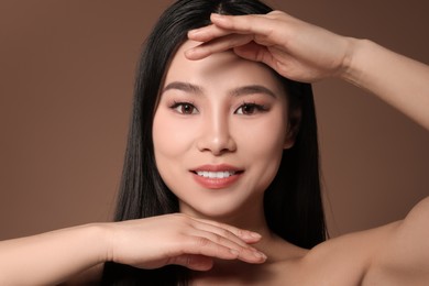 Photo of Portrait of beautiful woman on brown background