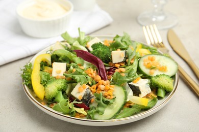 Photo of Delicious salad with lentils, vegetables and cheese served on light grey table