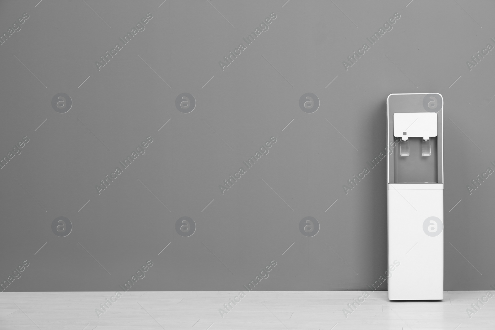 Photo of Modern water cooler against gray wall with space for text