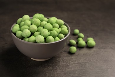 Tasty wasabi coated peanuts on grey table, closeup. Space for text