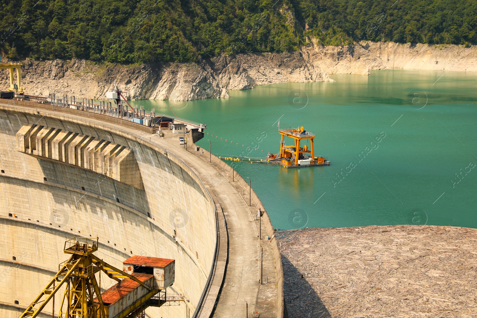 Photo of BATUMI, GEORGIA - AUGUST 13, 2022: Tower crane and hydroelectric power station in mountains