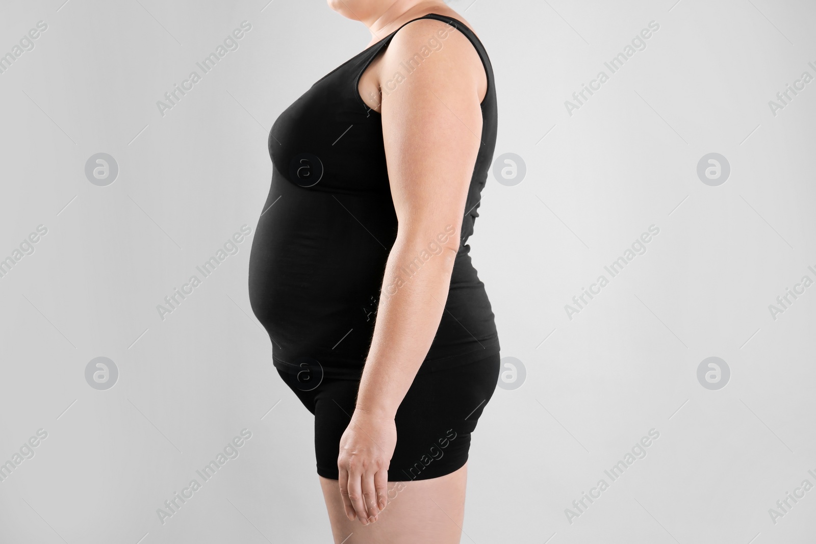 Photo of Fat woman on grey background, closeup. Weight loss