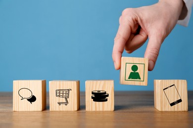 Image of Professional buyer. Man putting wooden cube with green human icon into row with other cubes, closeup