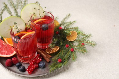 Photo of Aromatic Christmas Sangria in glasses served on light textured table, space for text