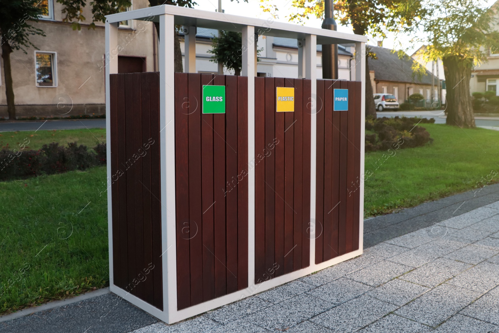 Photo of Different sorting bins for waste recycling on city street outdoors