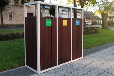 Different sorting bins for waste recycling on city street outdoors