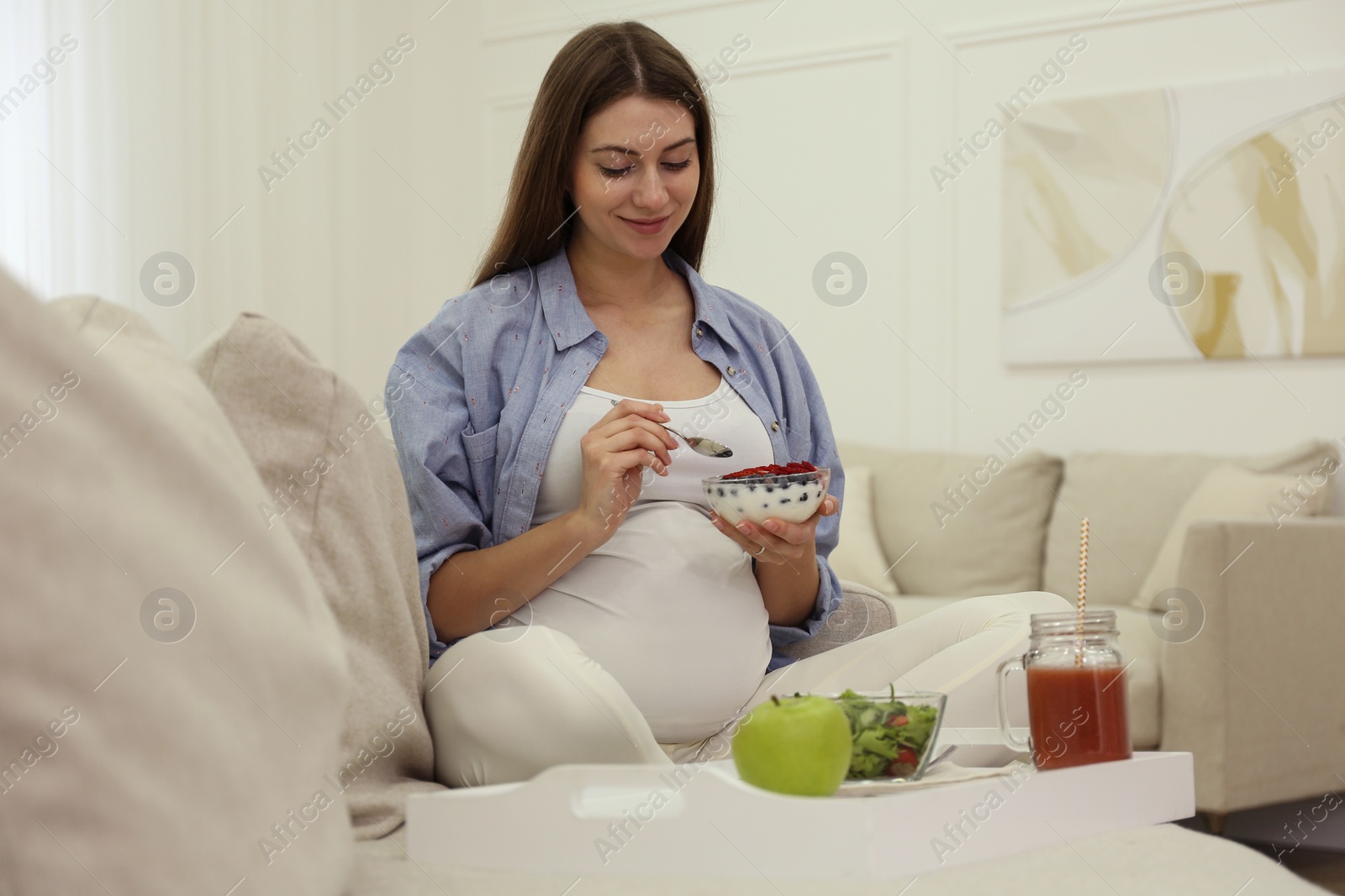 Photo of Pregnant woman eating breakfast at home. Healthy diet