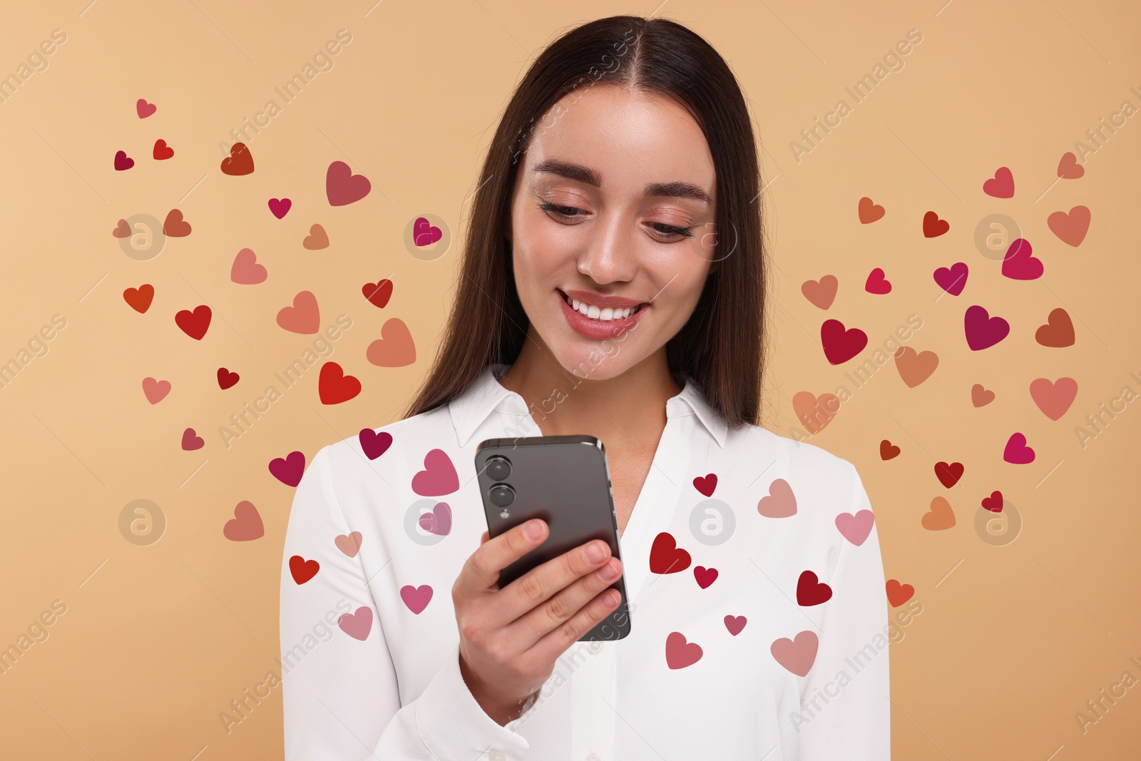 Image of Long distance love. Woman chatting with sweetheart via smartphone on dark beige background. Hearts flying out of device and swirling around her