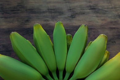 Photo of Bunch of delicious bananas on wooden table, closeup
