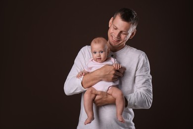 Photo of Happy father with his little baby on dark background
