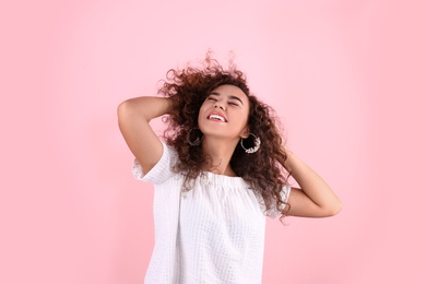 Photo of Portrait of young laughing African-American woman on color background