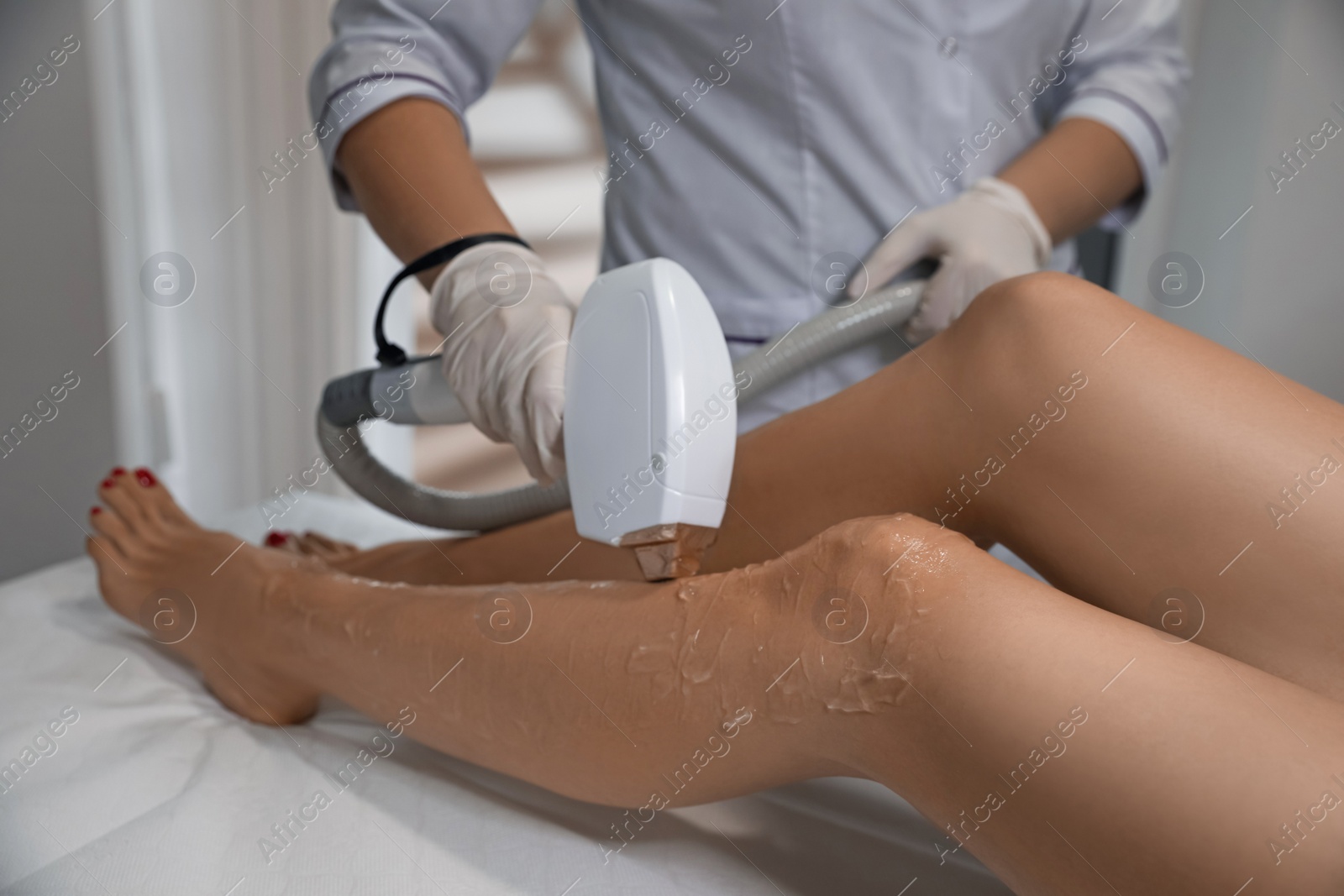 Photo of Woman undergoing laser epilation procedure in beauty salon, closeup