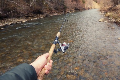 Photo of Man fishing in river, closeup. First person view