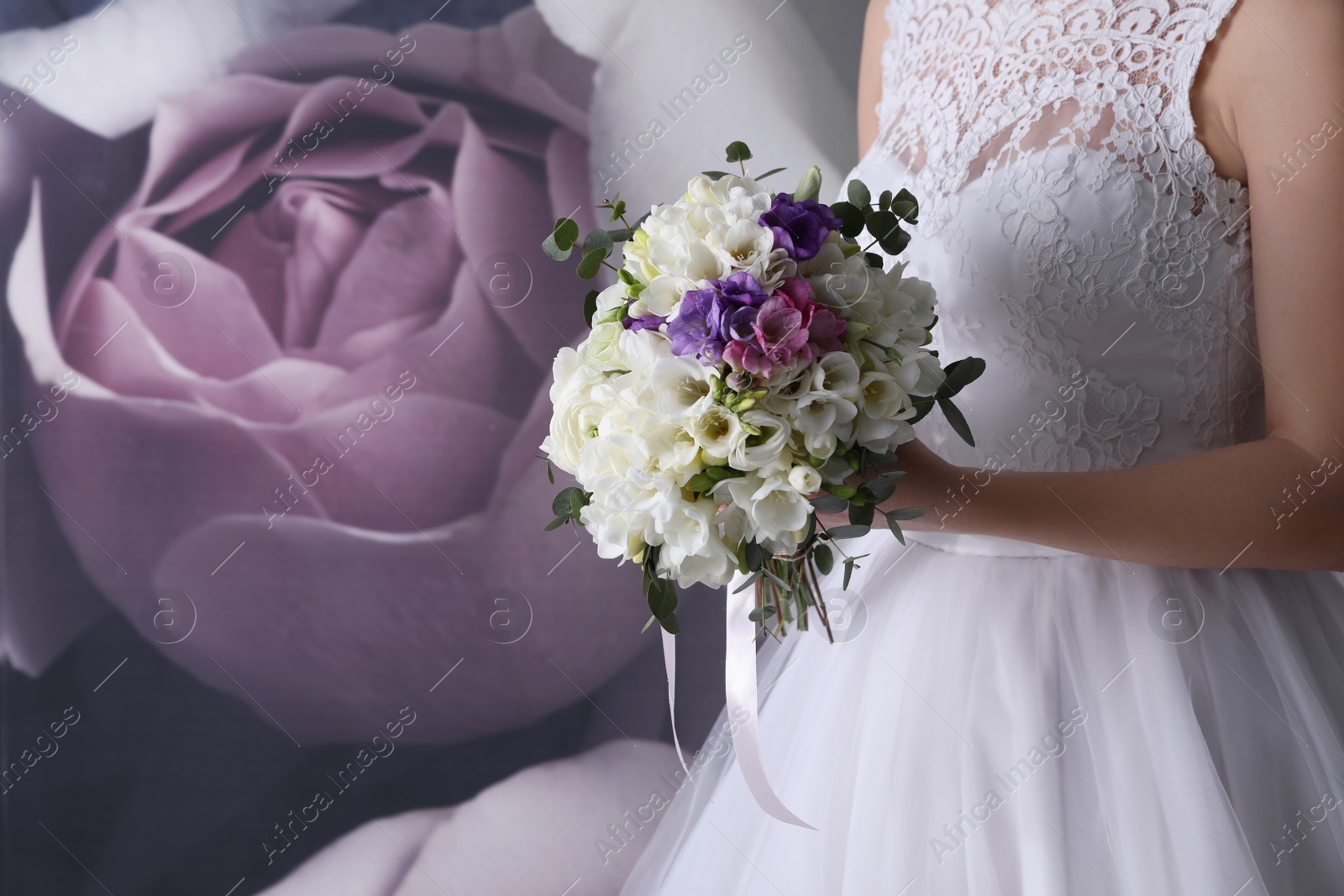 Photo of Bride holding beautiful bouquet with spring freesia flowers, closeup