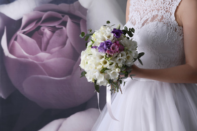 Bride holding beautiful bouquet with spring freesia flowers, closeup