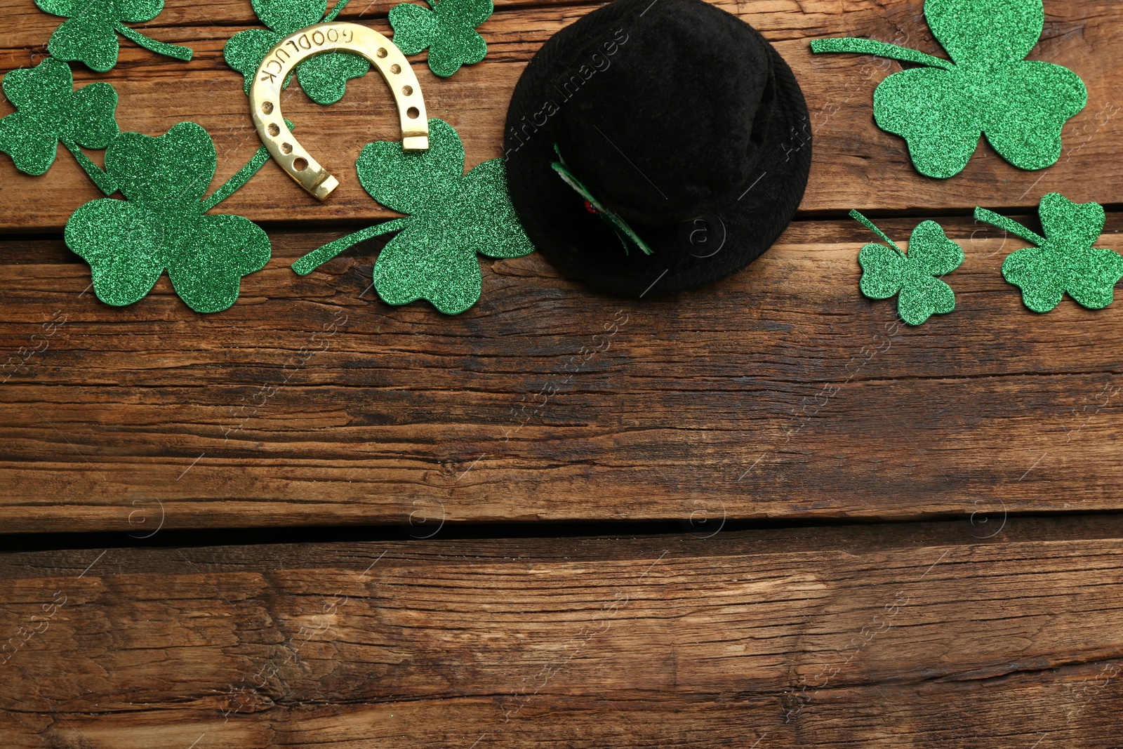Photo of Flat lay composition with leprechaun hat on wooden table, space for text. St Patrick's Day celebration
