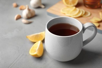 Photo of Cup of hot tea as natural cough remedy on table