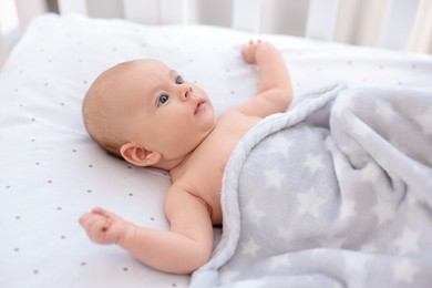 Photo of Cute little baby lying in crib at home