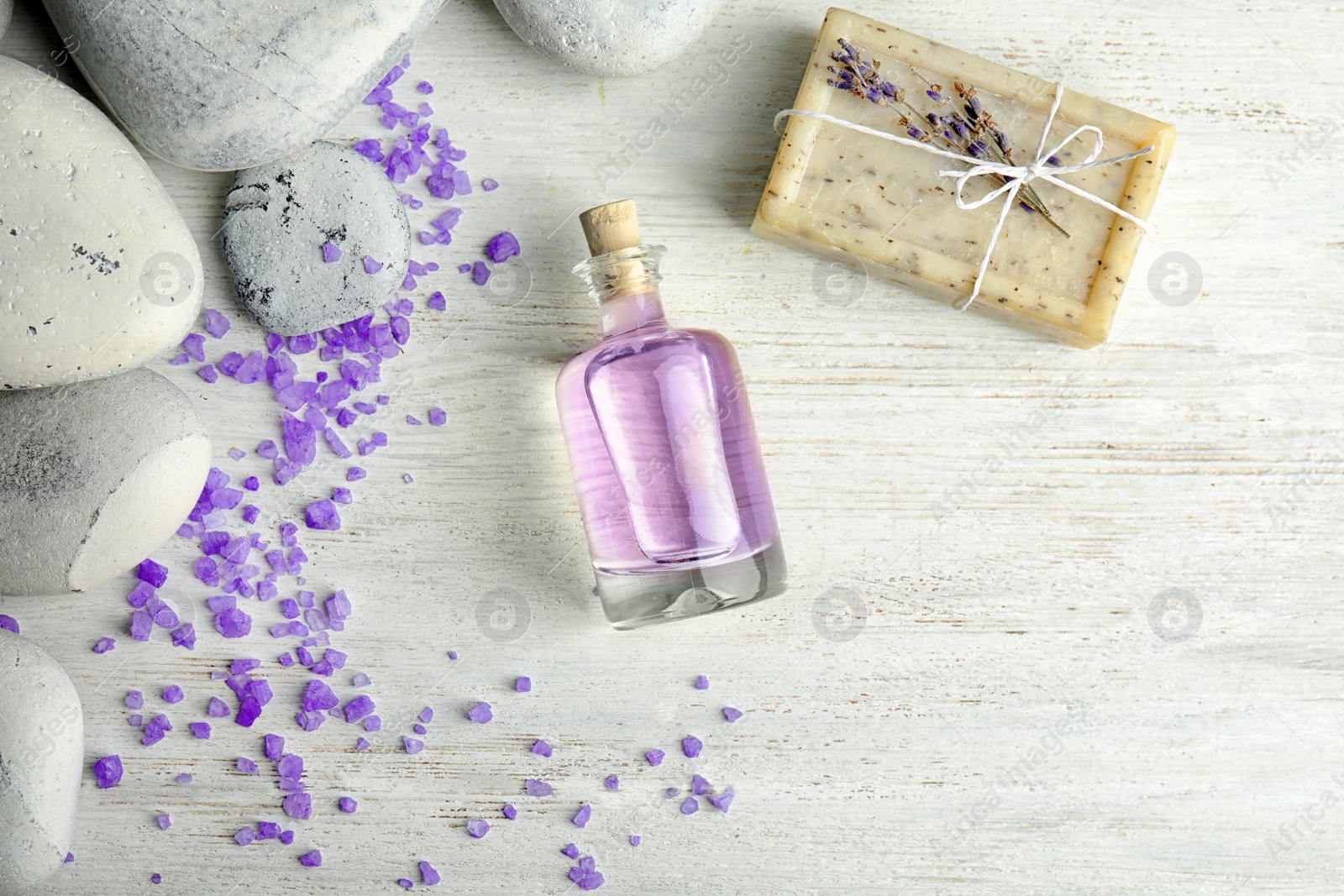 Photo of Flat lay composition with natural herbal oil, soap and lavender flowers on wooden background. Space for text