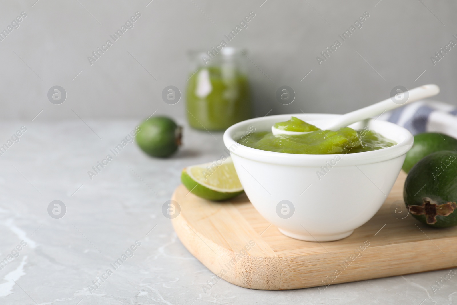 Photo of Feijoa jam on light grey marble table, space for text