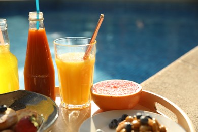 Tray with delicious breakfast near swimming pool, closeup