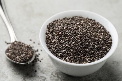 Bowl with chia seeds on grey table