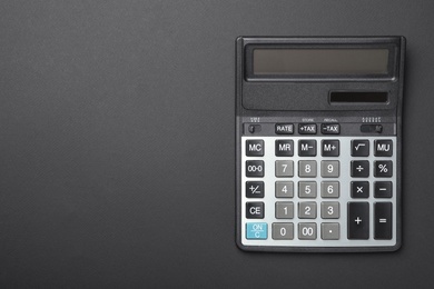 Photo of Calculator and space for text on black background, top view. Tax accounting concept