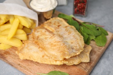 Photo of Delicious fish and chips with mangold on gray table, closeup