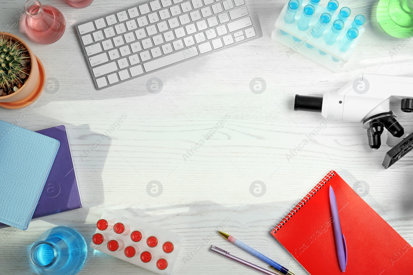 Photo of Flat lay composition with laboratory glassware, microscope and stationery on white wooden background, space for text. Chemistry concept