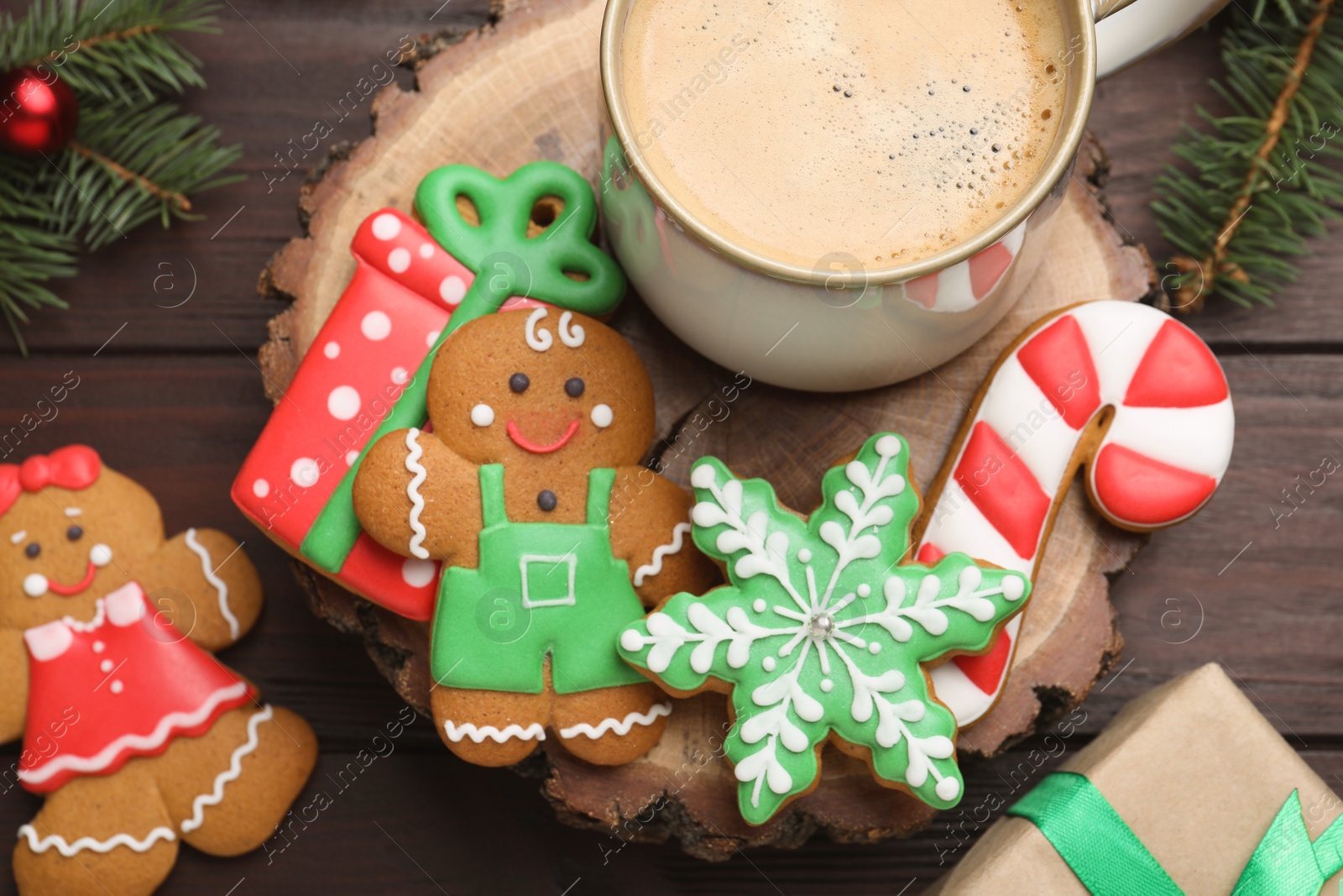 Photo of Decorated Christmas cookies and cup of delicious drink on wooden table, flat lay