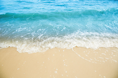 Photo of Sea waves rolling on beautiful sandy beach. Summer vacation