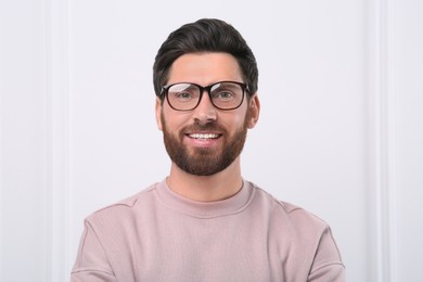 Portrait of handsome man near white wall