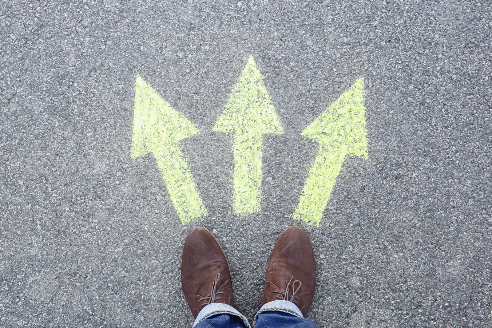 Photo of Man standing on road near arrows marking, closeup