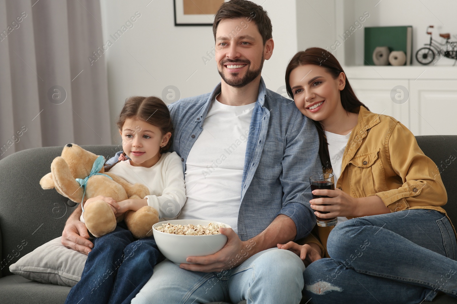 Photo of Happy family watching TV on sofa at home