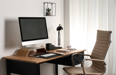 Stylish workplace interior with modern computer on table. Mockup for design