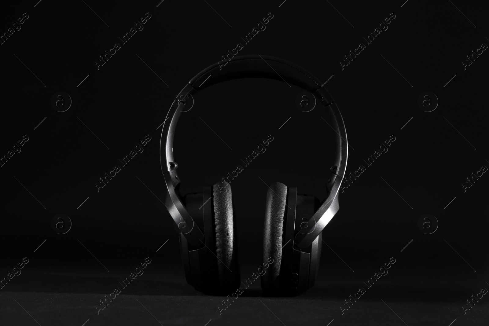 Photo of Stylish modern wireless headphones on black background