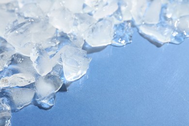 Photo of Pieces of crushed ice on light blue background, above view. Space for text