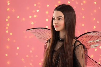 Beautiful girl in fairy costume with wings on pink background, space for text
