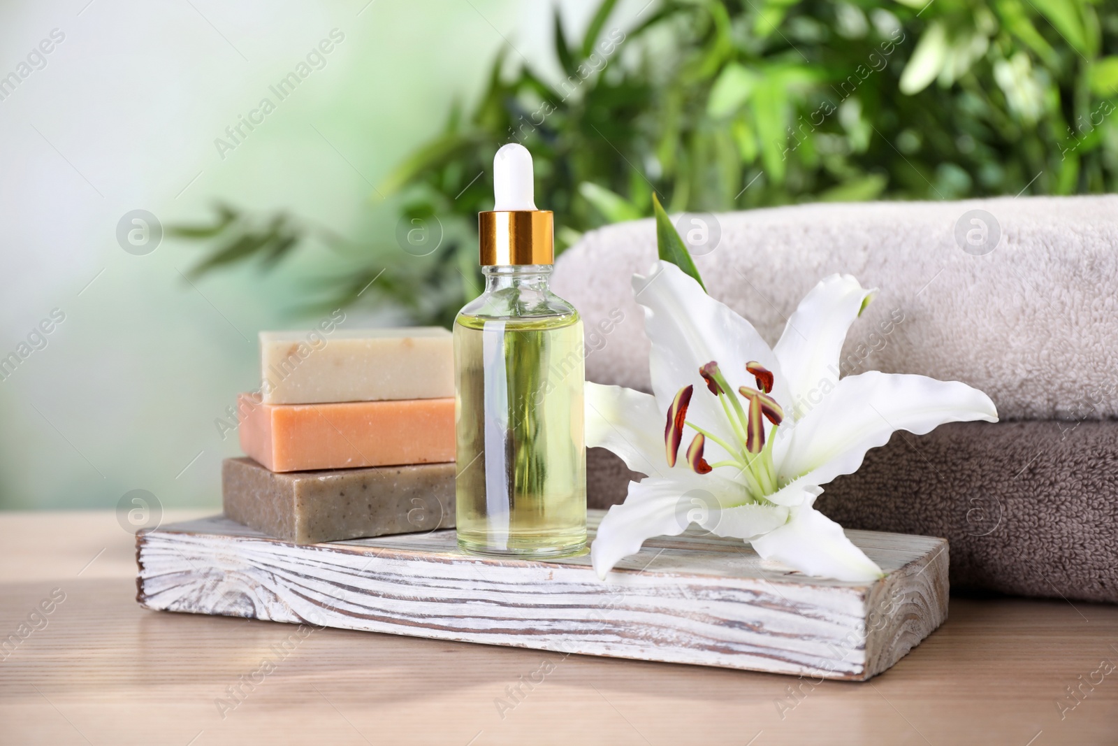 Photo of Composition with flower and spa supplies on wooden table, space for text