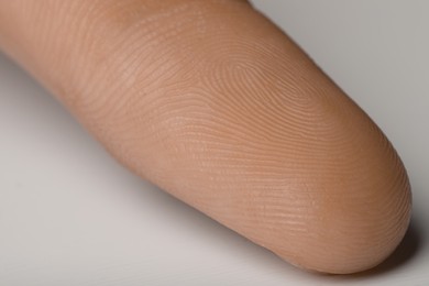Closeup view of human finger on white background