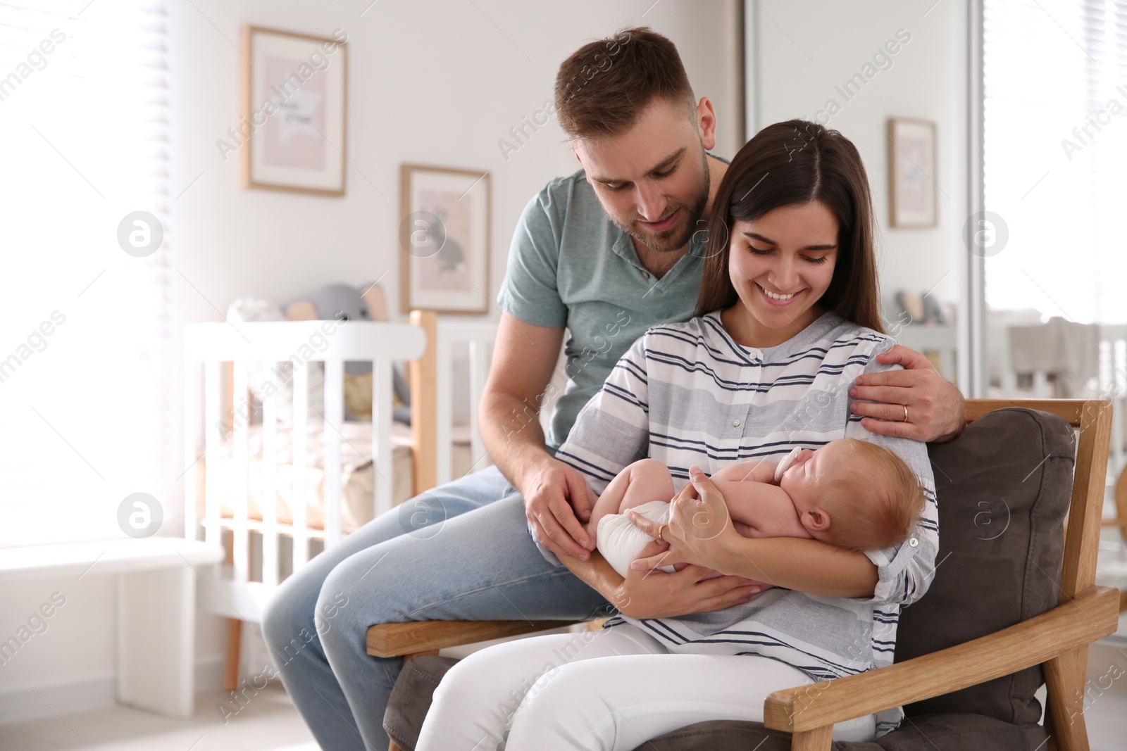 Photo of Happy couple with their newborn baby at home