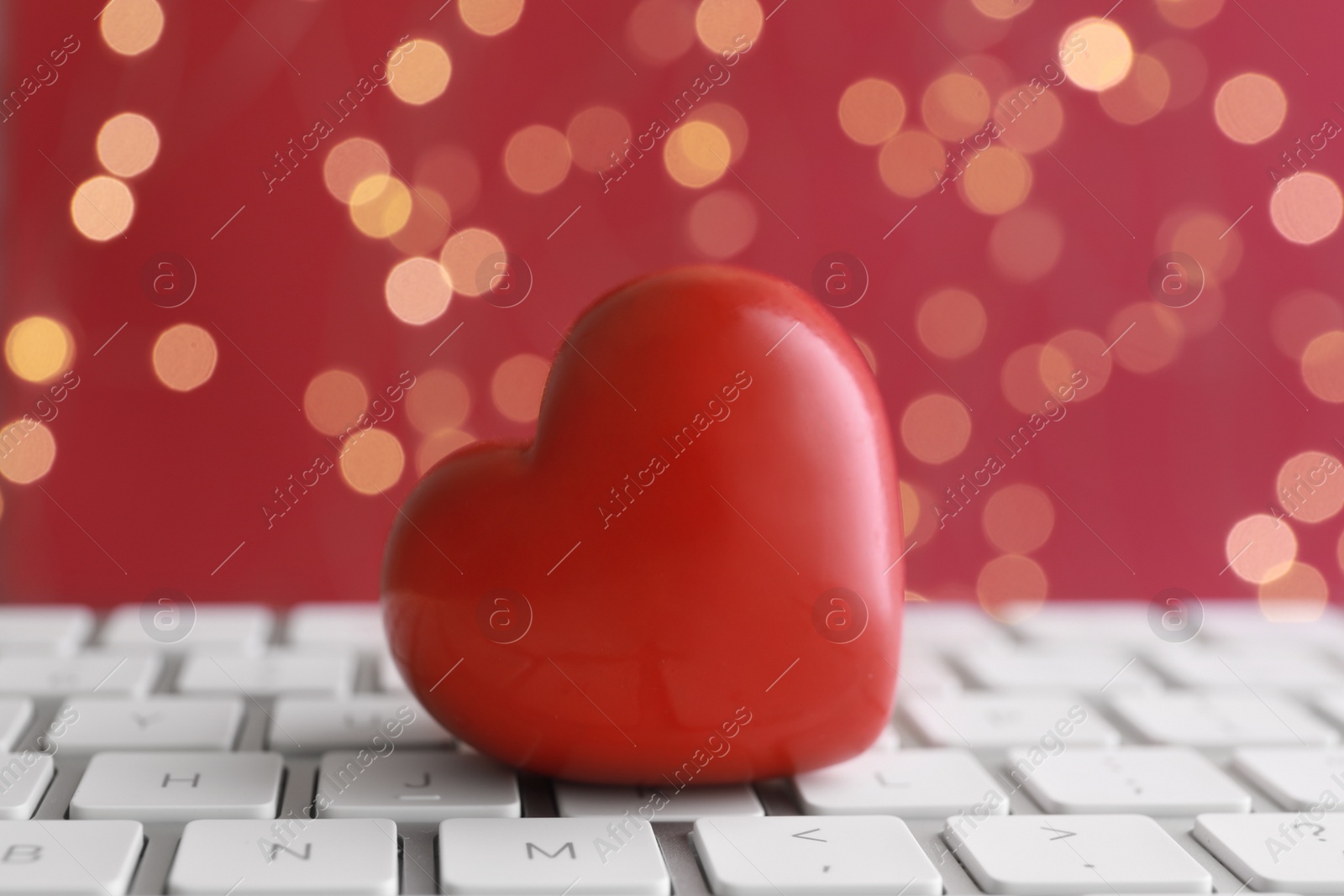 Photo of Red decorative heart on laptop, closeup. Online dating