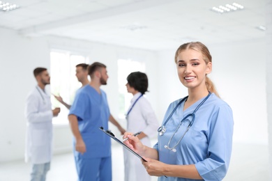 Photo of Portrait of female doctor in uniform and her colleagues at workplace