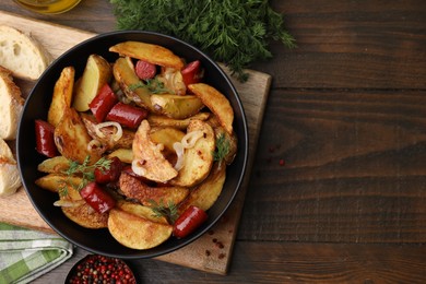 Delicious baked potato with thin dry smoked sausages in bowl, bread and spices on wooden table, flat lay. Space for text