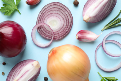 Flat lay composition with onion and spices on light blue background