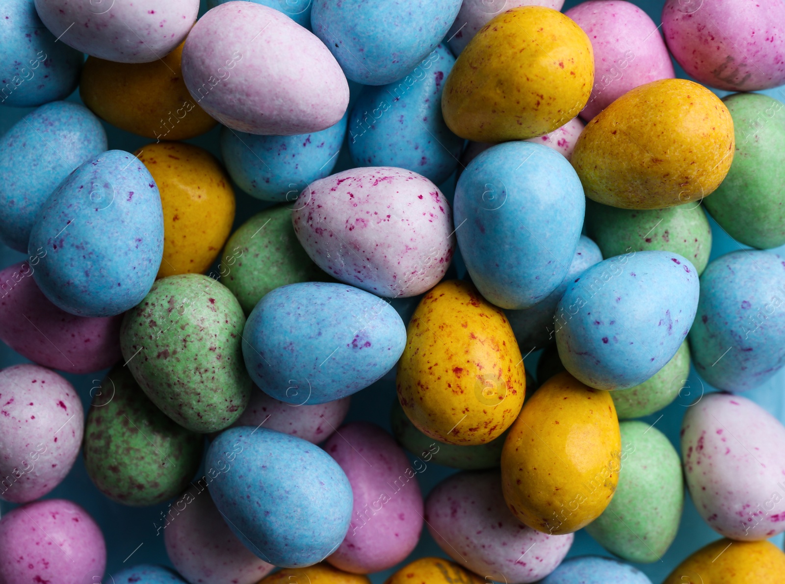 Photo of Many delicious colorful dragee candies as background, top view