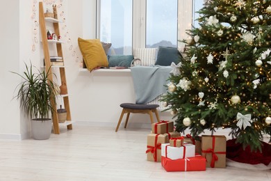 Photo of Beautiful Christmas tree and gift boxes in stylish room. Interior design