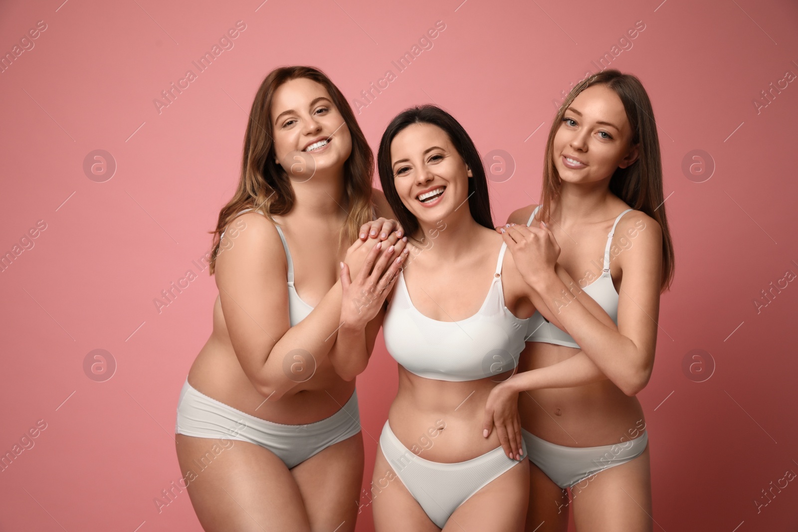 Photo of Group of women with different body types in underwear on pink background